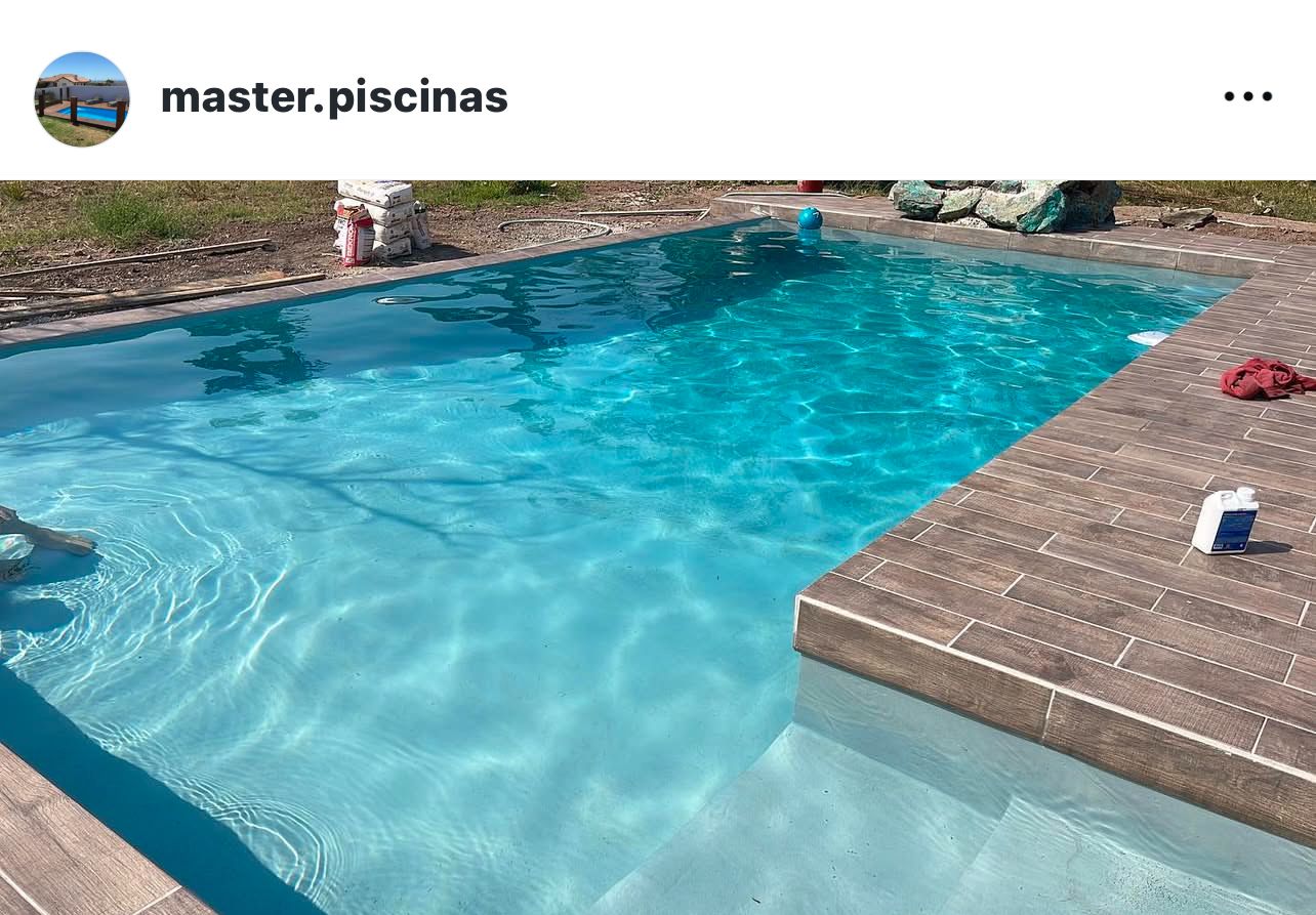 Piscina rectangular turquesa cristalina con spa decorativo al fondo