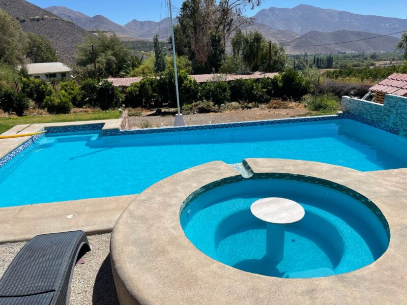 Piscina rectangular con jacuzzi circular integrado y mosaico azul eléctrico