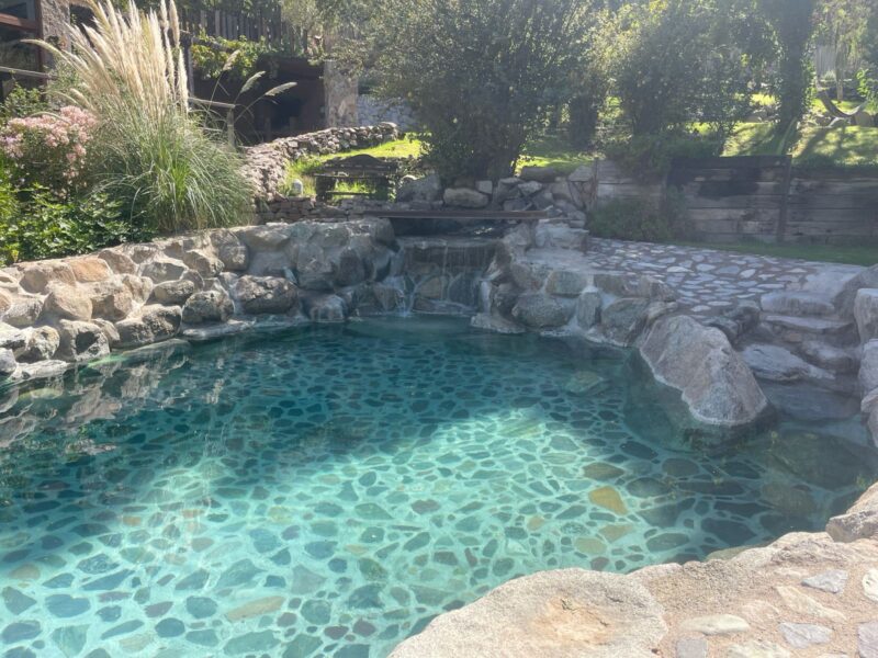 Piscina natural con cascada de piedra y agua turquesa cristalina
