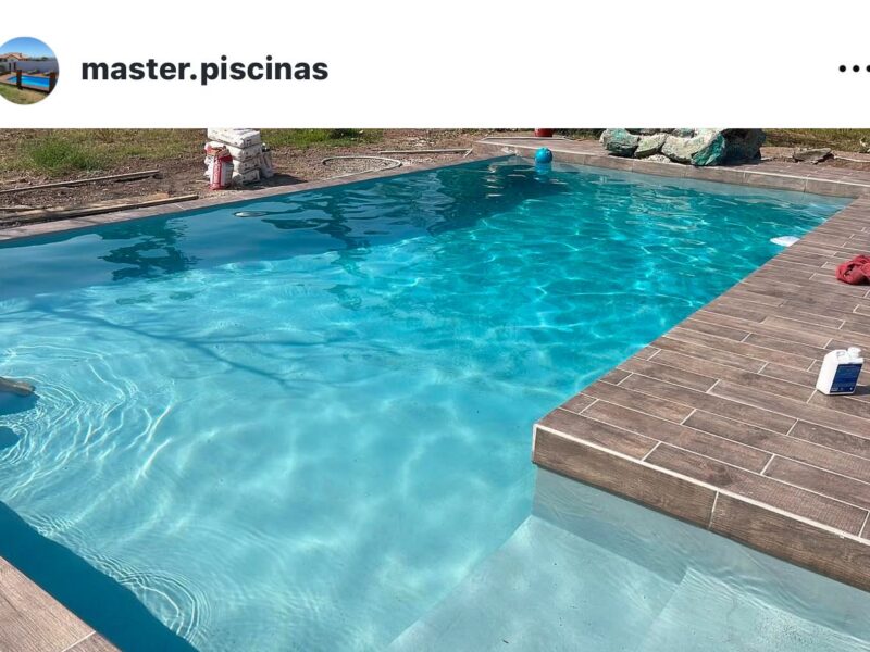 Piscina rectangular turquesa cristalina con spa decorativo al fondo