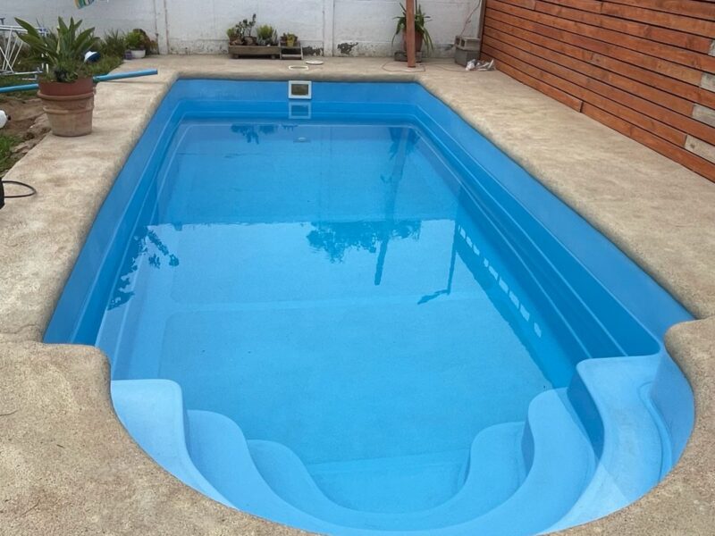 Piscina fibra de vidrio con escalones internos y cerca de madera