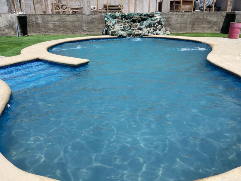 Piscina natural tipo laguna en ecolodge con vegetación y cerros al fondo