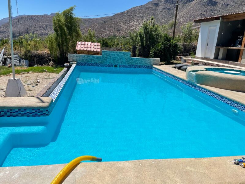 Piscina rectangular grande con spa integrado y mosaico azul multicolor
